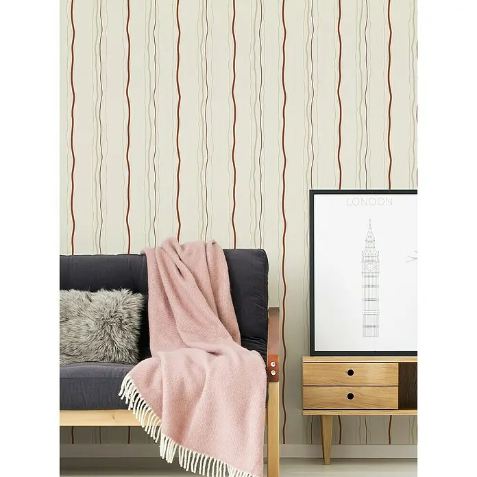 A.S. Création Casual Living Vliestapete - Creme/Rot/Beige, Streifen, 10,05 x 0,53 m - Eine Nahaufnahme eines gemütlichen Wohnzimmers mit einem stilvollen Sofa, einer weichen Decke und einer dekorativen London-Grafik.