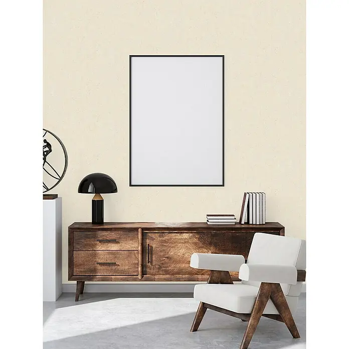 A.S. Création Casual Living Vliestapete Struktur - Beige, Uni, 10,05 x 0,53 m - Eine Inneneinrichtung mit einem stilvollen Sideboard aus dunklem Holz, einem modernen Sessel und einem gerahmten Bild an der Wand.