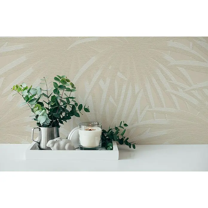 A.S. Création Casual Living Vliestapete Palmenblätter - Beige/Weiß, Floral, 10,05 x 0,53 m - Stillleben mit Kerze, Pflanze und Dekoration auf einem Tablett vor einer Wand mit Blattmuster, das ein Gefühl von Ruhe und Natürlichkeit vermittelt.