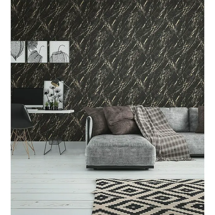 A.S. Création Casual Living Vliestapete MarmorSchwarz/Gold/Metallic, Steinoptik, 10,05 x 0,53 m - Elegantes Wohnzimmer mit stilvoller Couch, Schreibtisch und einem auffälligen geometrischen Teppich auf hellem Holzboden.