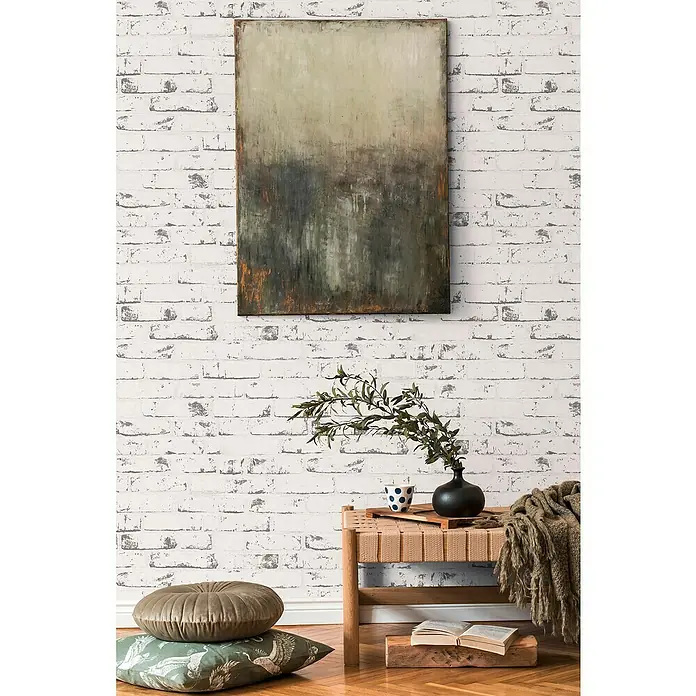 A.S. Création Casual Living Vliestapete New England Klinker - Grau/Anthrazit, Steinoptik, 10 x 0,53 m - Dekorative Leinwand mit abstraktem Landschaftsmotiv, ideal für moderne Wohnräume, hängt über einer Bank mit Pflanzen.