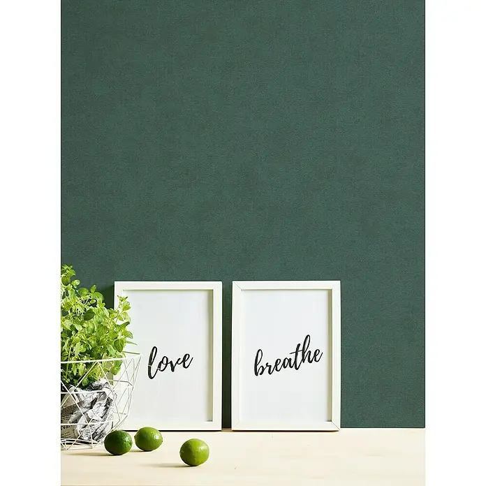 A.S. Création Casual Living Vliestapete - Grün, Uni, 10,05 x 0,53 m - Ein stillvolles Arrangement mit zwei gerahmten Schriftzügen "Liebe" und "Atmen", begleitet von frischen Limetten und Grünpflanzen.