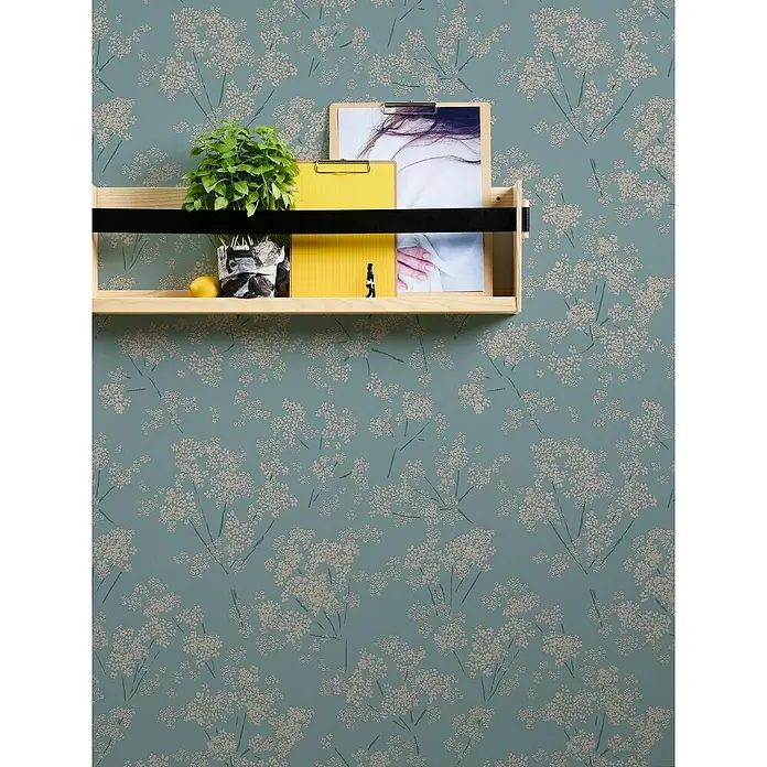 A.S. Création Casual Living Vliestapete Blümchen - Blau/Beige/Türkis, Floral, 10,05 x 0,53 m - Holzregal an blumiger Wand. Das Regal beherbergt eine Pflanze, Büroartikel und eine Zitrone und betont die natürliche Ästhetik des Designs.