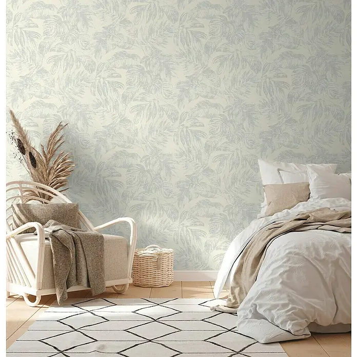 A.S. Création Casual Living Vliestapete - Weiß/Silber/Creme, Floral, 10,05 x 0,53 m - Nahaufnahme einer hellen Schlafzimmerwand mit tropischem Blättertapetenmuster, die eine ruhige, natürliche Atmosphäre schafft.