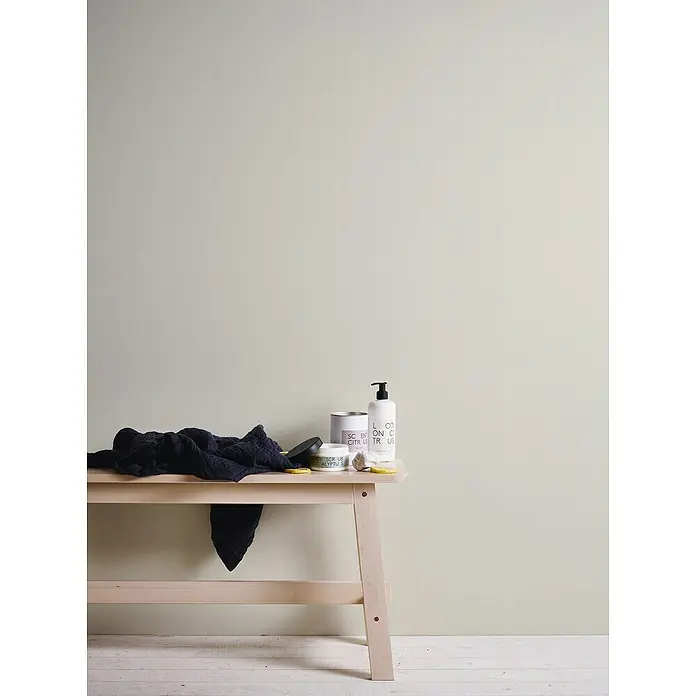 A.S. Création Casual Living Vliestapete - Cremefarben, Uni, 10,05 x 0,53 m - Körperpflegeprodukte, darunter Lotion, Peeling und ein Handtuch, sind auf einem Holztisch ausgestellt. Diese Produkte versprechen eine natürliche Schönheitsroutine.