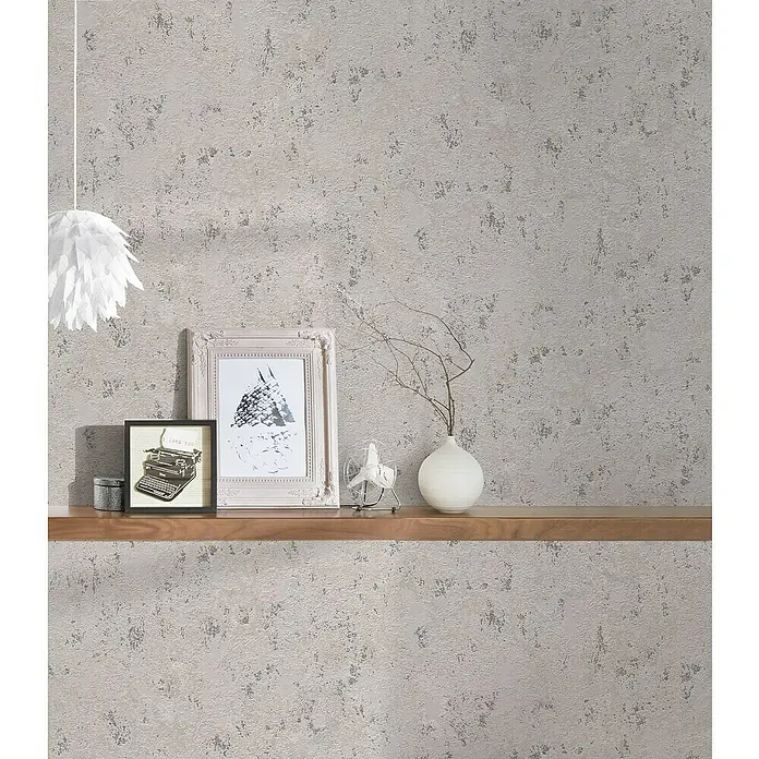 A.S. Création Casual Living Vliestapete Struktur - Grau/Beige/Silber, Uni, 10,05 x 0,53 m - Nahaufnahme eines dekorierten Regals mit einer Lampe, Rahmen und einer Vase auf einem Hintergrund mit Textur.