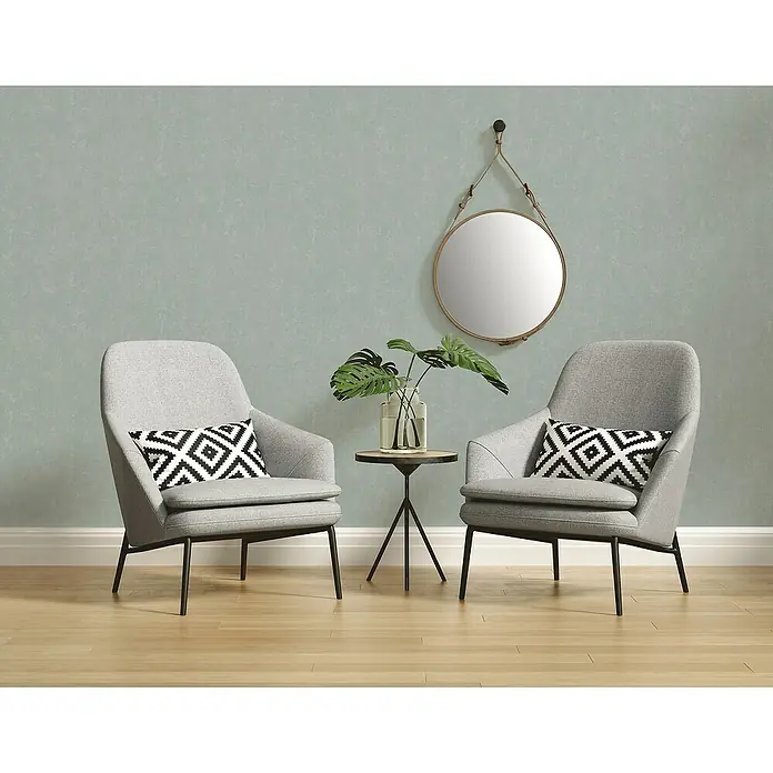 A.S. Création Casual Living Vliestapete - Mintblau, Uni, 10,05 x 0,53 m - Zwei graue Sessel mit einem kleinen Tisch und einem Spiegel, die ein gemütliches Ambiente schaffen. Die Sessel laden zum Entspannen ein.