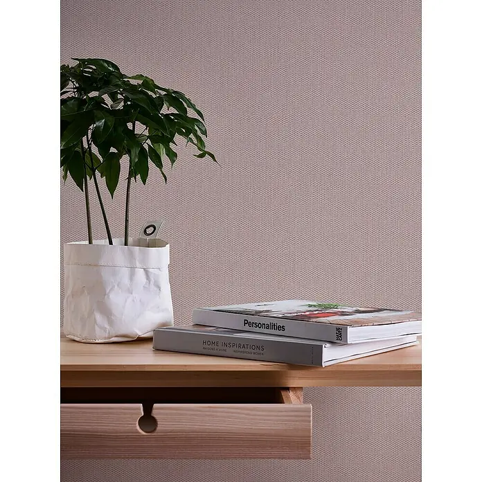 A.S. Création Casual Living Vliestapete Strukturtapete - Rosa/Silber, Uni, 10,05 x 0,53 m - Nahaufnahme eines hellen Holzregals mit einer Pflanze, zwei Büchern und einer Schublade mit einem runden Griff.