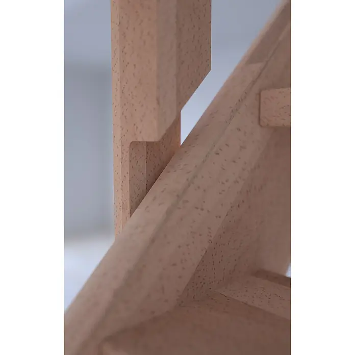 Starwood Raumspartreppe Mykonos - Breite: 81 cm, Buche, Geschosshöhe: 280 cm, Gerade, Montageseite Geländer: Links, Geländer Holz/Edelstahl weiß, Mit Setzstufen - Nahaufnahme von einem hellbraunen Holzstuhl. Die Maserung des Holzes und die Konstruktion des Möbelstücks sind deutlich erkennbar.