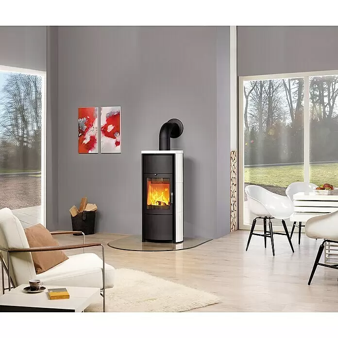 Hark Kaminofen Keno ECOplus - 5 kW, Raumheizvermögen: 138 m³, Material Verkleidung: Keramik, Creme/Weiß - Ein moderner schwarz-weißer Kaminofen mit sichtbarem Feuer, auf einer Glasplatte in einem zeitgenössischen Wohnzimmer.