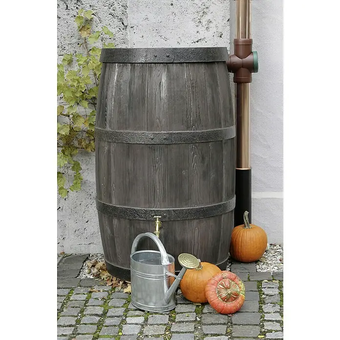 Arves Regenspeicher Burgund - 500 l, Dunkelbraun - Regentonne aus Kunststoff in Holzoptik mit Zubehör wie Gießkanne und Kürbissen, die eine herbstliche Gartenszene erzeugen.