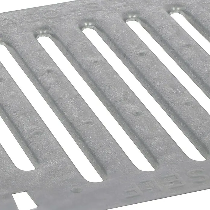 ACO Self Stegrost - 25 x 25 x 0,3 cm, Verzinkt - Nahaufnahme eines grauen Entwässerungsgitters mit länglichen Schlitzen und einer leicht rauen Oberfläche.