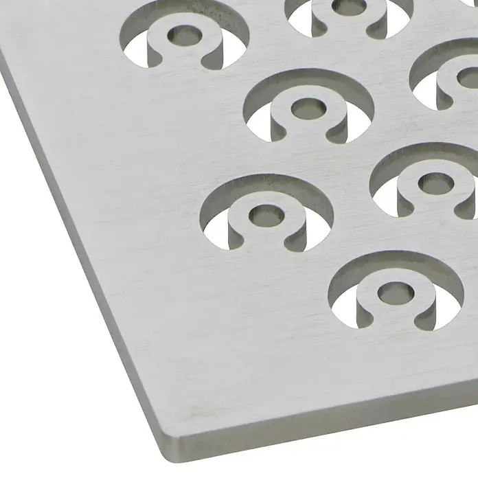ACO Designrost Raindrops - 102,5 mm x 102,5 mm, Edelstahl - Nahaufnahme einer quadratischen Metallplatte mit kreisförmigen Aussparungen für Schrauben. Ideal für Möbelbau und DIY-Projekte.