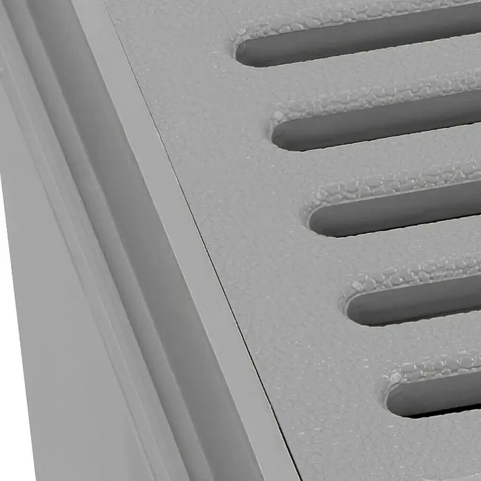 RUG Self Kellerablauf - Ablauf: Seitlich, Durchmesser: 110 mm, 254 x 184 mm - Nahaufnahme einer grauen, perforierten Oberfläche, vermutlich Teil eines Produkts mit strukturiertem Finish und parallelen Schlitzen.