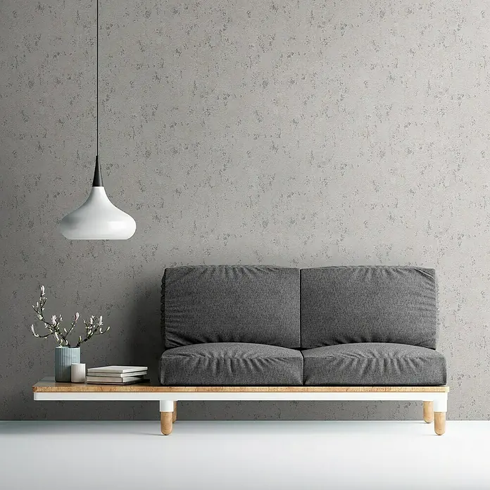 A.S. Création Casual Living Vliestapete Struktur - Grau/Beige/Silber, Uni, 10,05 x 0,53 m - Dieses Bild zeigt ein modernes graues Sofa mit passender Pendelleuchte, das ein stilvolles und minimalistisches Wohnambiente erzeugt.