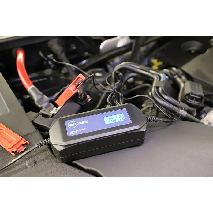 Cartrend Automatik-Ladegerät DP4.1Ladestrom: 4 A - Autobatterieladegerät "cartrend Ladegeät 4A SB1459" in Aktion, mit Klemmen an der Batterie und Anzeige von 12.4V.