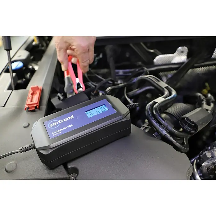 Cartrend Automatik-Ladegerät DP10.1 - Ladestrom: 10 A - Ein Cartrend Ladegerät 10A SB1541 wird zum Laden einer Autobatterie verwendet, wobei ein Hand eine Klemme hält.