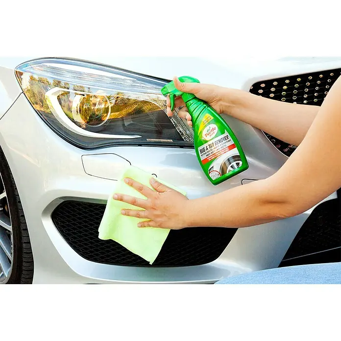 Turtle Wax Eliminador de insectos y resinas de árboles - 500 ml - Aplicando Turtle Wax Bug & Tar Remover a un coche para eliminar insectos y alquitrán, con un paño de microfibra verde.