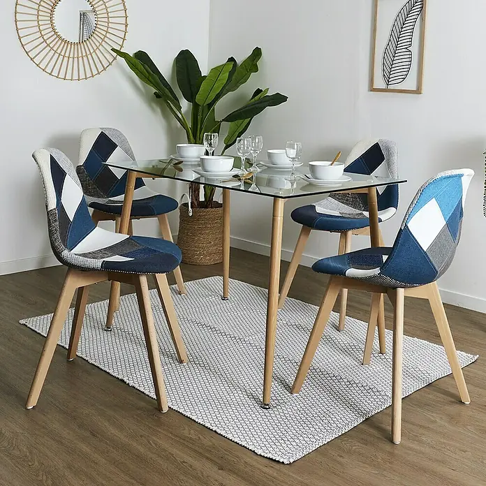 Home Deco Factory Silla Patchwork - Azul/Gris, 4 pzs. - La imagen muestra una mesa de comedor con tapa de cristal y cuatro sillas patchwork azul y blanco en una habitación luminosa.