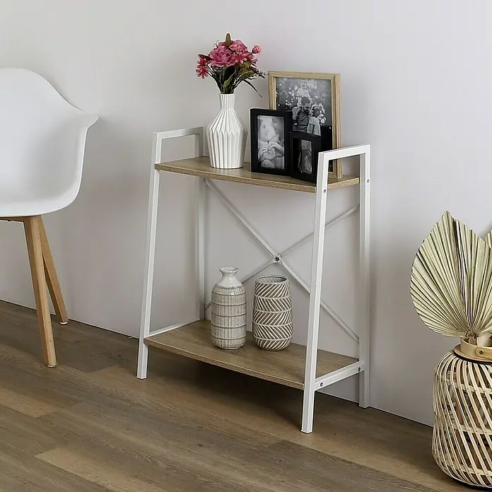 Home Deco Factory Estantería de madera Natural Crush - L x An x Al: 27 x 60 x 70 cm, Blanco - La foto muestra una estantería decorativa de dos niveles con acabado de madera clara y estructura de metal blanco, donde se exponen jarrones y marcos de fotos.