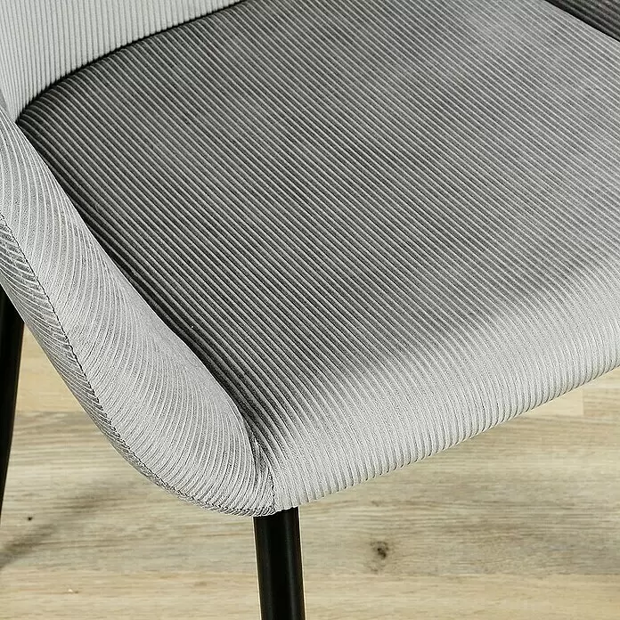 Home Deco Factory Silla butaca Giulia - Gris, 2 pzs. - Primer plano de una silla de pana gris claro con patas negras sobre suelo de madera.