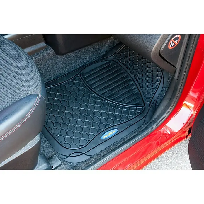 Goodyear Juego de alfombrillas para coche - 4 pzs., Negro - Alfombrilla negra Goodyear en el suelo de un coche rojo, diseñada para proteger el interior del vehículo.