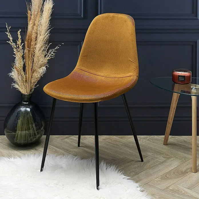 Silla Giulia - Mostaza, 4 pzs. - Silla de pana color mostaza con patas negras delgadas sobre una alfombra blanca, ideal para la decoración moderna.