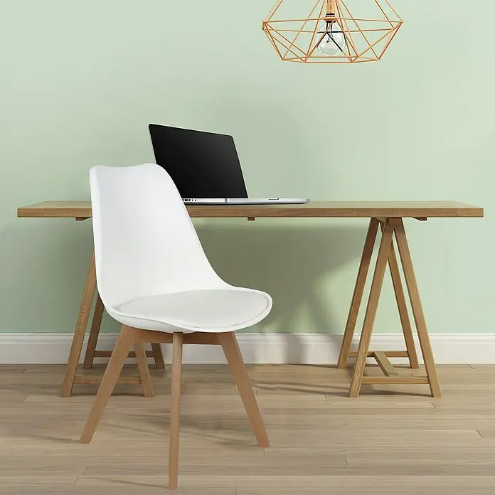 Silla Copenhague - Blanco, 4 pzs. - Un espacio de trabajo moderno con un portátil sobre un escritorio de madera y una elegante silla blanca con patas de madera en primer plano.