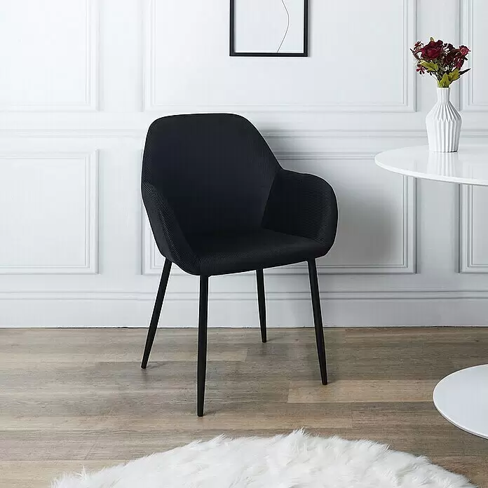 Silla butaca Giulia - Negro, 2 pzs. - Silla de comedor negra de tela texturizada con patas de metal negro, junto a una mesa blanca.