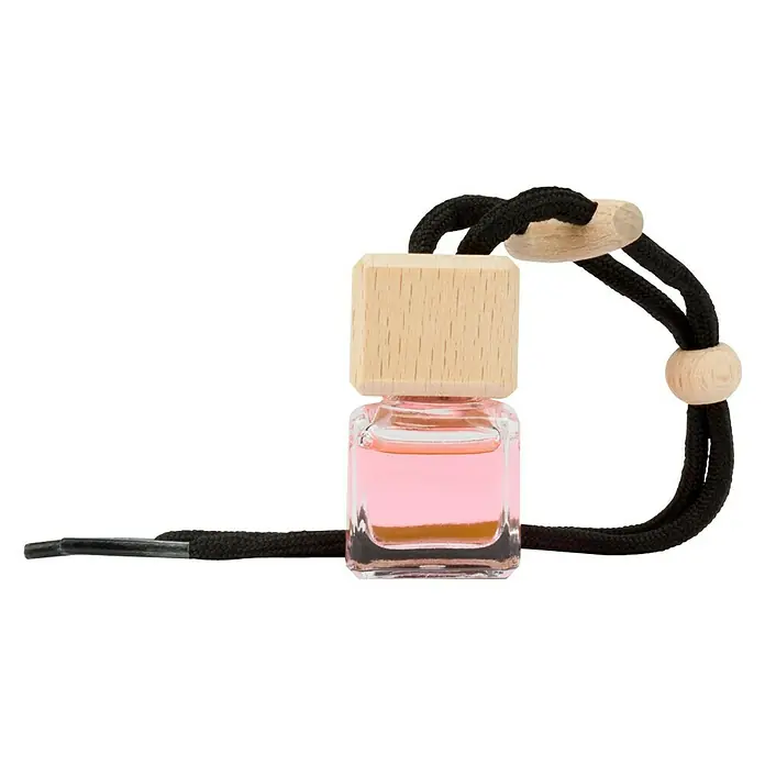 Ambientador de coche para colgar - Fresa, 8 sem. - Un ambientador cuadrado con tapa de madera y cordón negro, lleno de líquido rosa, para un ambiente agradable.