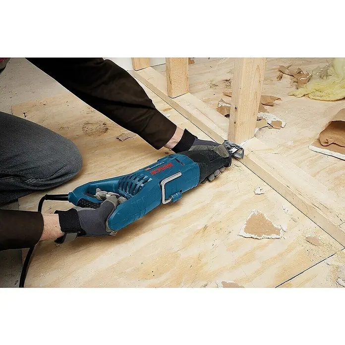 Bosch Professional Säbelsäge GSA 1100 E - 1.100 W, 2.700 /min - Ein Mann sägt ein Stück Holz mit einer blauen Bosch Säbelsäge. Sie ist ein robustes und leistungsstarkes Werkzeug für verschiedene Materialien.