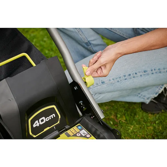 Ryobi ONE+ Akku-Rasenmäher RY18LMX40C-240 - 18 V, 2 Akkus, Schnittbreite: 40 cm - Detailaufnahme eines RYOBI Rasenmähers mit Bedienhebel und 40cm Schnittbreite, bedient von einer Person in Jeans.