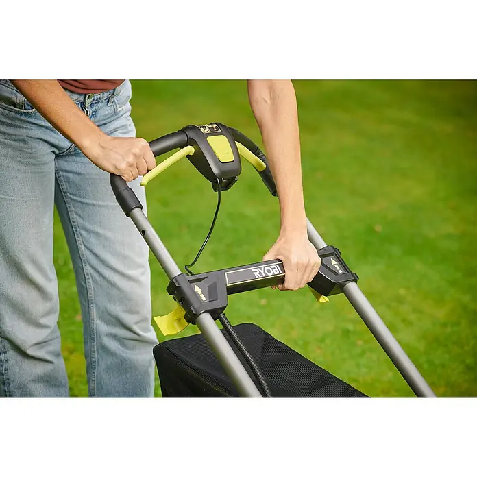 Ryobi ONE+ Akku-Rasenmäher RY18LMX40C-240 - 18 V, 2 Akkus, Schnittbreite: 40 cm - Eine Nahaufnahme des RYOBI-Rasenmähers, der von einer Person auf einem grünen Rasen bedient wird. Der Fokus liegt auf dem Griffbereich des Mähers.