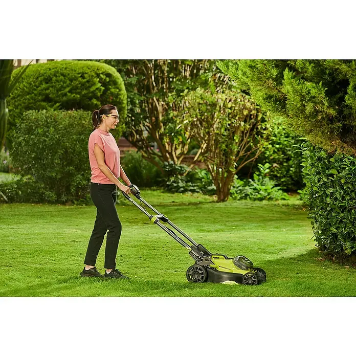 Ryobi ONE+ Akku-Rasenmäher RY18LMX40C-240 - 18 V, 2 Akkus, Schnittbreite: 40 cm - Eine Frau benutzt einen Sun Joe Rasenmäher, um den Rasen in einem Garten zu mähen, umgeben von üppigem Grün.