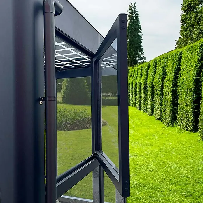 SunElements Gewächshaus-Seitenfenster - Passend für: Sun Garden Gewächshäuser Infinity & Energy in Anthrazit-Metallic - Ein detailreiches Foto von einem modernen Wintergarten mit einer geöffneten Glastür, die den Blick auf den grünen Garten freigibt.