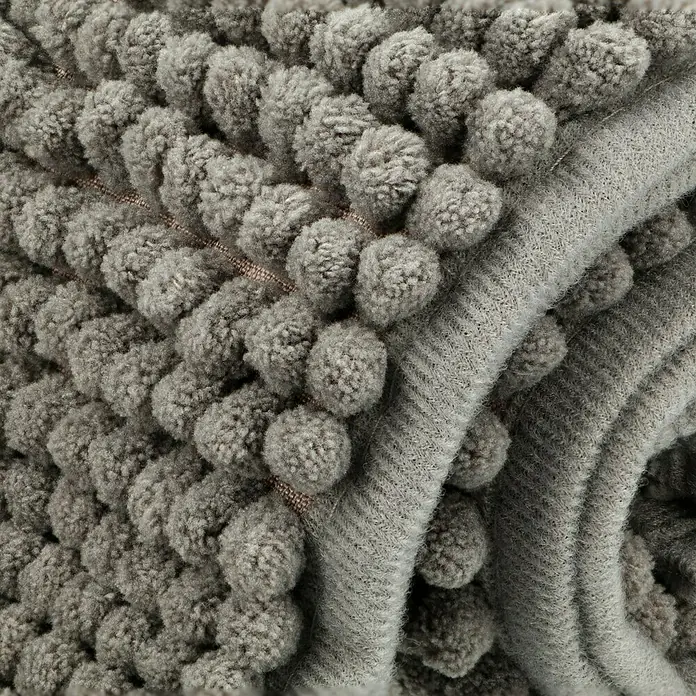 Bad-Accessoire-Set Today 2 - 4 -tlg., Grau - Nahaufnahme einer flauschigen, grauen Badematte mit Pompons und strukturiertem Rand.