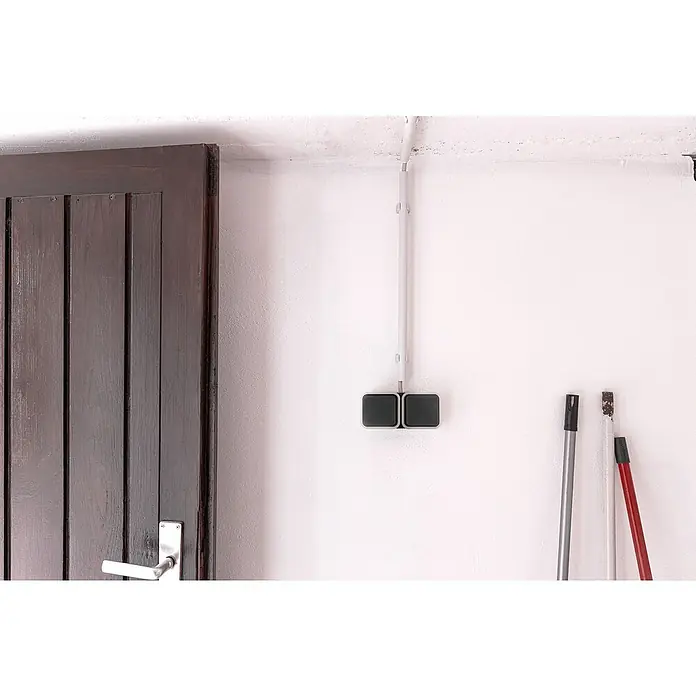 Hamburg Feuchtraum-Steckdose - 2-fach, Grau/Anthrazit, Horizontal, IP55 - Eine Nahaufnahme einer braunen Holztür neben einer weißen Wand mit einem grauen Schalter und Stielwerkzeugen.
