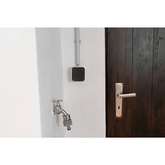 Hamburg Kreuzschalter - Grau/Anthrazit, Aufputzmontage, IP55 - Nahaufnahme eines an der Wand montierten schwarzen Smart-Home-Geräts, das Technologie und modernes Design vereint.