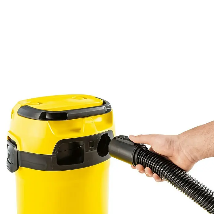 Kärcher Aspirador en seco y húmedo eléctrico WD 3 V-17/4/20 - 1.000 W, Volumen de recipiente: 17 l - Una aspiradora amarilla con una manguera negra está siendo operada por una mano. La aspiradora es compacta y para uso versátil.