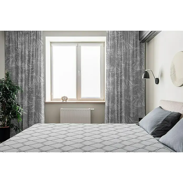 Cortina con ollaos Triana - An x Al: 140 x 270 cm, Gris - Dormitorio con cortinas grises, cama con estampado geométrico, lámpara de noche y planta en maceta.
