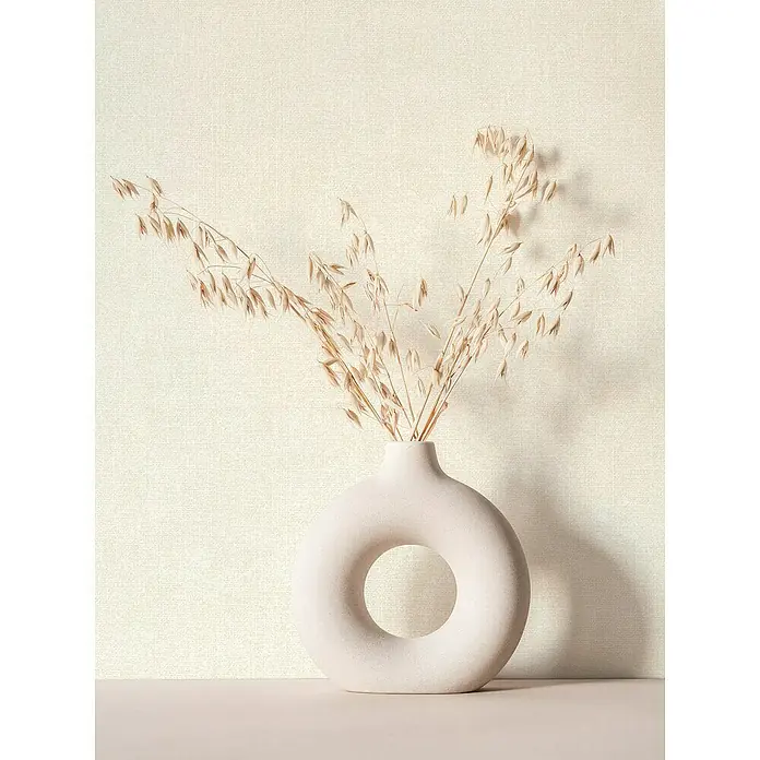 Marburg Struktura Vliestapete Struktur - Weiß, Uni, 10,05 x 0,53 m - Eine elegante, donutförmige Vase in sanftem Beige mit zarten, getrockneten Blumen, die eine ruhige und stilvolle Atmosphäre schafft.