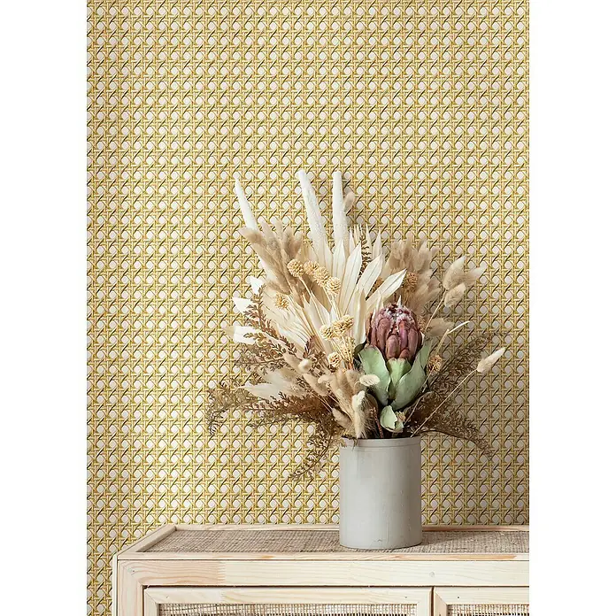 Marburg Struktura Vliestapete Holzgeflecht - Beige, Holzoptik, 10,05 x 0,53 m - Blumengesteck mit Trockenblumen in einer grauen Vase auf einem Holzschrank vor einem gemusterten Hintergrund.