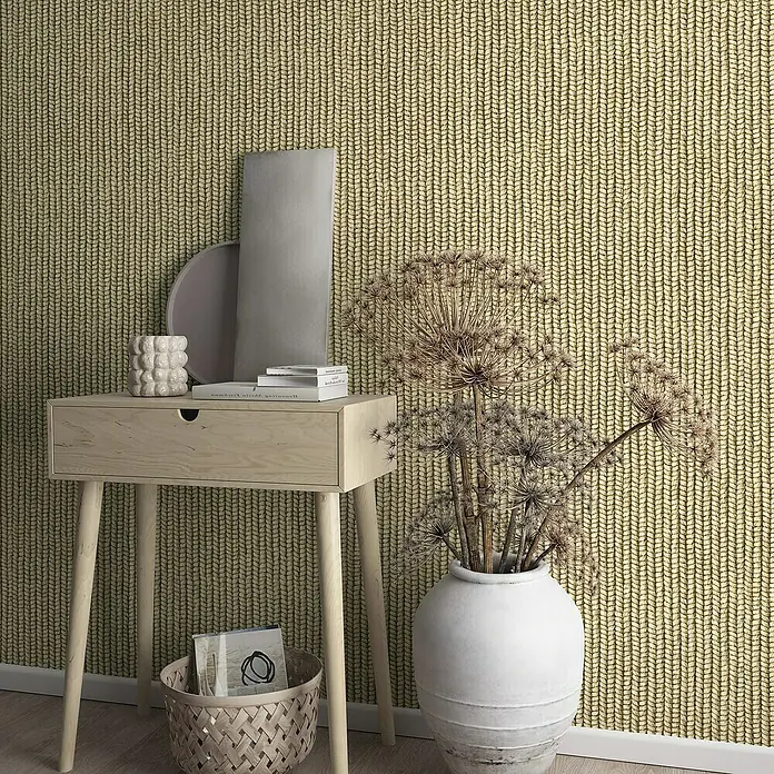 Marburg Struktura Vliestapete Holzgeflecht Textiloptik - Beige/Braun, Holzoptik, 10,05 x 0,53 m - Nahaufnahme eines skandinavisch inspirierten Beistelltisches aus hellem Holz mit einer Schublade und schlanken Beinen vor einer gestrickten Tapete.