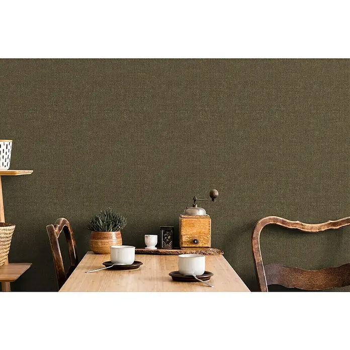 Marburg Struktura Vliestapete Struktur - Braun, Uni, 10,05 x 0,53 m - Produktaufnahme eines stilvollen Tisches mit rustikalen Elementen wie einer Kaffeemühle und Geschirr vor einer Leinwand-Textur.