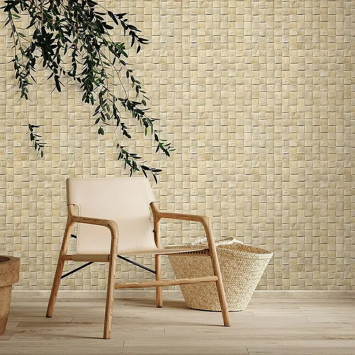 Marburg Struktura Vliestapete 3D-Geflecht - Hellbeige, 3D-Optik, 10,05 x 0,53 m - Ein schlichtes Interieur mit einem eleganten Sessel mit Holzrahmen und einem dekorativen Korb vor einer strukturierten Wand.