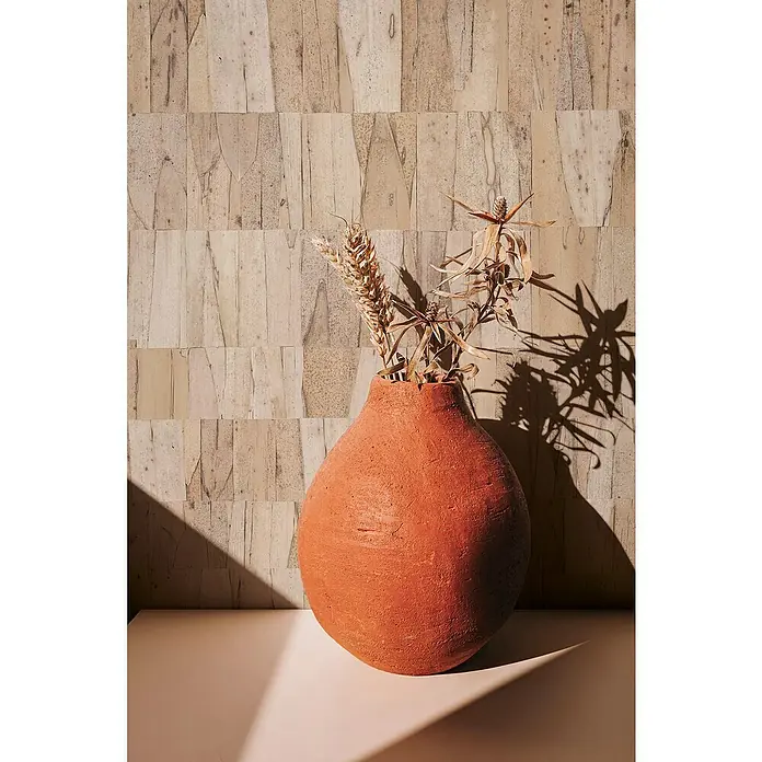Marburg Struktura Vliestapete Echtholz - Braun, Holzoptik, 10,05 x 0,53 m - Terracotta-Vase mit Trockenblumen vor einer Wand mit Blattmuster. Ein stimmungsvolles Interieur-Stillleben.