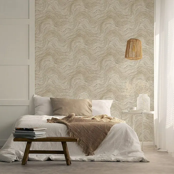 Marburg Struktura Vliestapete Marmoroptik - Grau/Beige, Steinoptik, 10,05 x 0,53 m - Schlafzimmer mit Bett, Nachttisch und Lampe vor einer Wand mit gewelltem Muster.