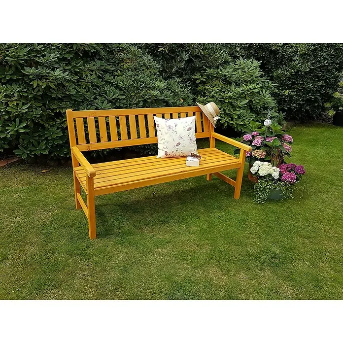 Promadino Gartenbank Johanna - B x T x H: 154 x 71 x 88,5 cm, Kiefer, Honigbraun - Gelbe Gartenbank mit Kissen, Hut, Buch und Blumen auf einem Rasen. Entspannende Gartenszene mit rustikalem Charme.