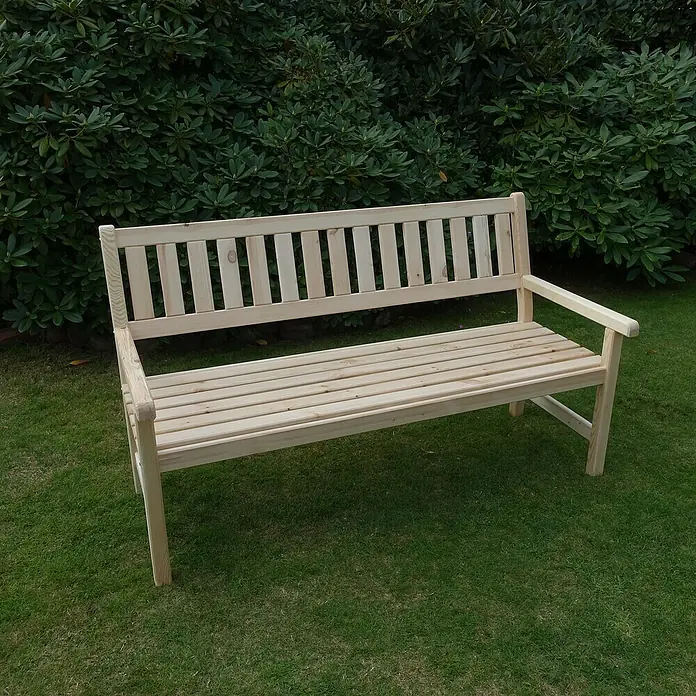 Promadino Gartenbank Johanna - B x T x H: 154 x 71 x 88,5 cm, Kiefer, Natur - Eine unbehandelte Holzbank mit Armlehnen steht auf einer grünen Rasenfläche vor einem grünen Busch.