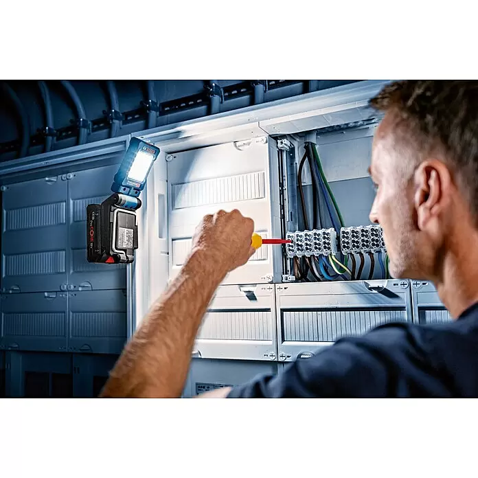 Bosch Professional AMPShare 18V Proyector LED de batería GLI 18V-800 - 18 V, Sin batería, Flujo luminoso: 800 lm - Luz de trabajo Bosch Professional con batería ProCORE 18V iluminando un panel eléctrico en uso.